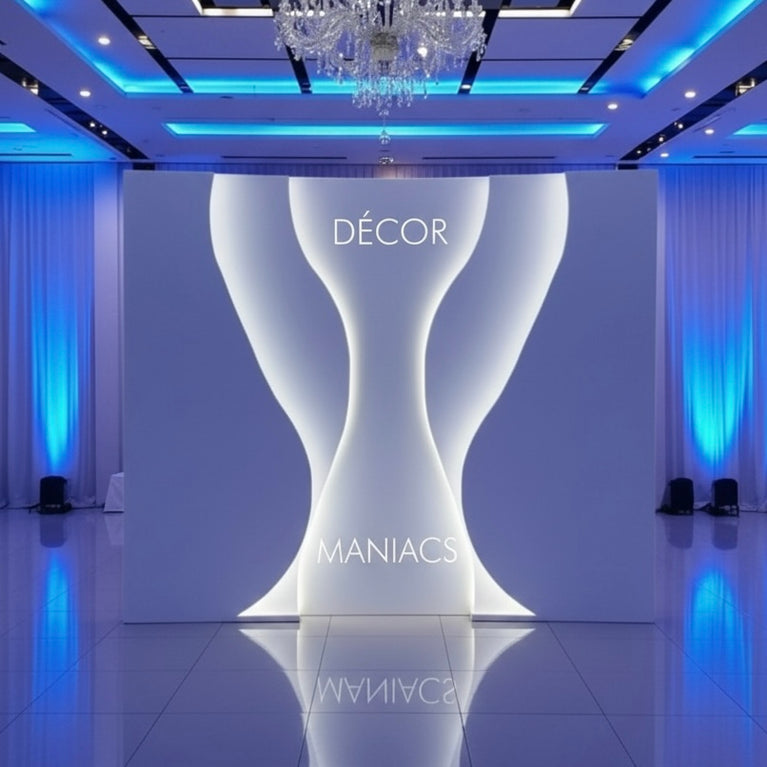 Decorative white backdrop stand with 'Décor Maniacs' branding in a room with blue lighting.