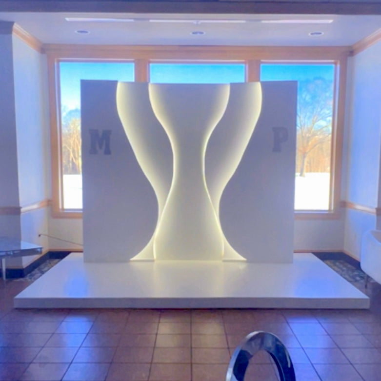Modern white backdrop sculpture in a room with large windows