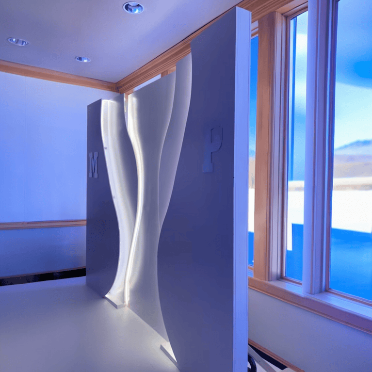 Modern backdrop design with a curved white wall feature near a large window.